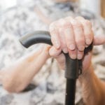 Alte Frau mit Gehstock in der Altenpflege