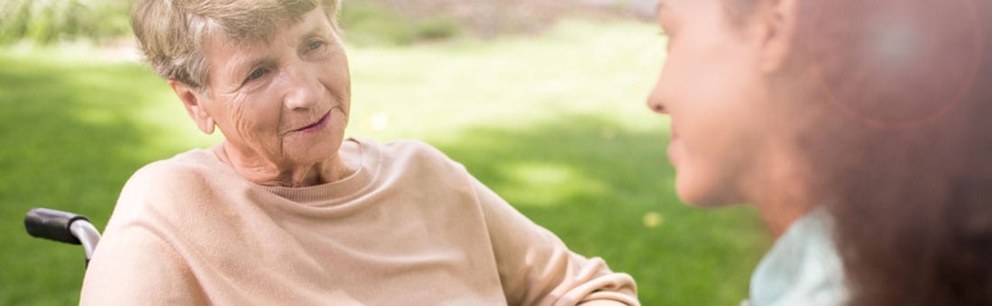 Altenpflegerin und ältere Dame im Rollstuhl Pflegegeld beantragen für Pflegekräfte